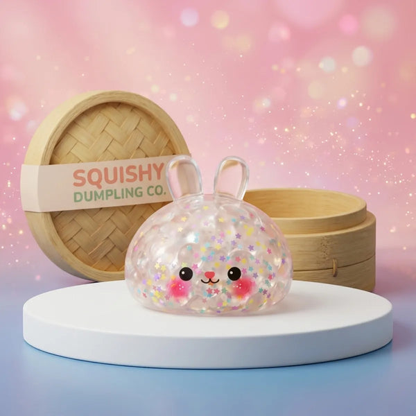 Hoppy Bunny Bubble Dumpling Squishy on a white studio podium beside a steamer basket