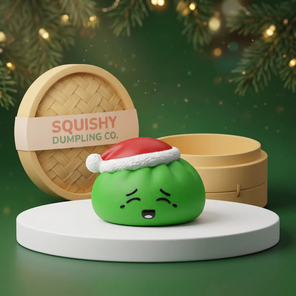 Elf Green Christmas Hat Dumpling Squishy on a white studio podium beside a steamer basket