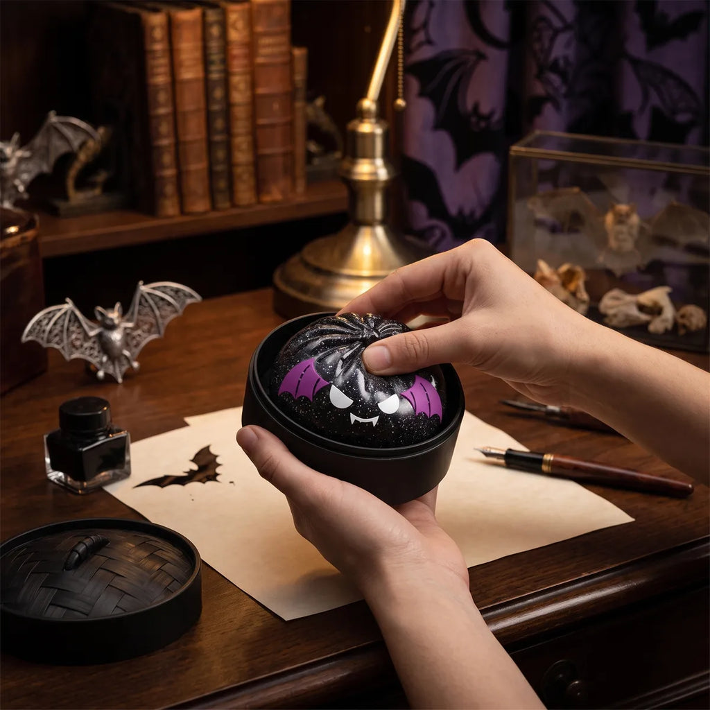 Person using the bat Halloween dumpling squishy as a hand fidget toy