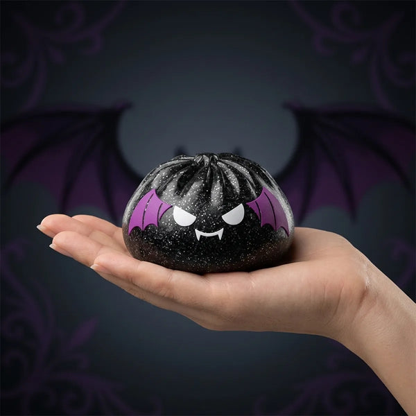 Hand holding the 9 cm bat Halloween dumpling squishy to show its real size