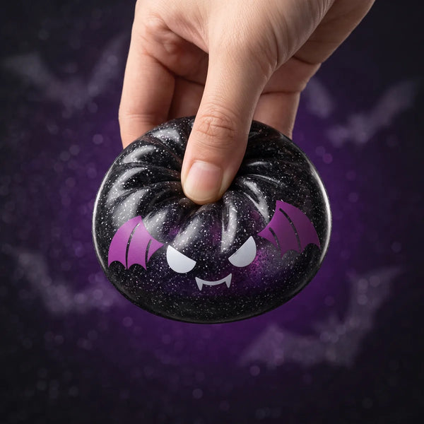 Bat Halloween dumpling squishy squeezed flat to show its slow rising black glitter gel