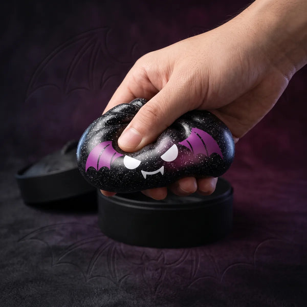 Close up squeeze showing the soft skin and sparkling black glitter of the bat Halloween dumpling squishy