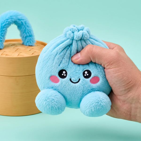 Fingers pinching the Sky Blue Dumpling Squishy Plush to show how soft it is
