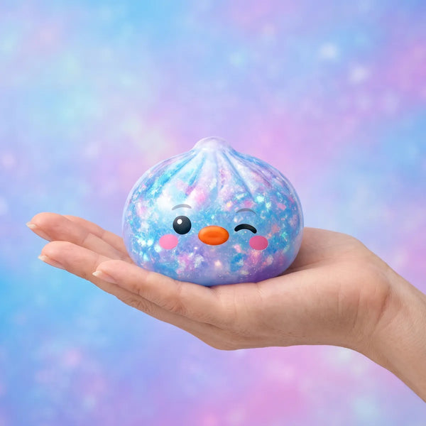 Hand holding the 5.5 cm blue penguin dumpling squishy to show its size