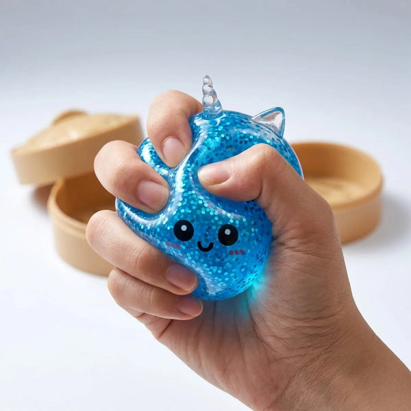 Close up squeeze of the blue unicorn glitter dumpling squishy showing its dense cobalt glitter