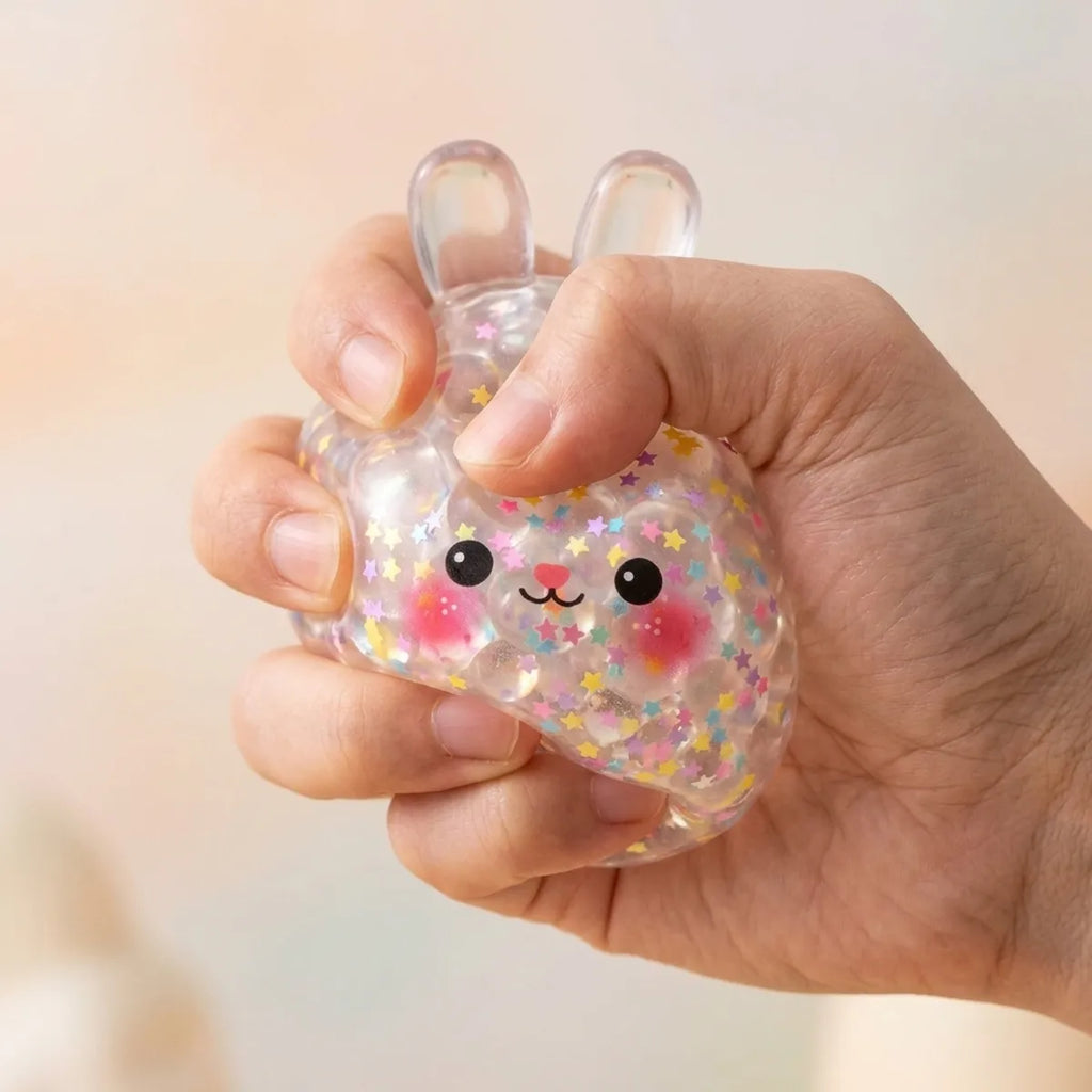 Hand squeezing the Hoppy Bunny Bubble Dumpling Squishy so the confetti beads move inside