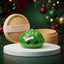 Grumpy Christmas Evil Dumpling Squishy on a white studio podium beside a steamer basket