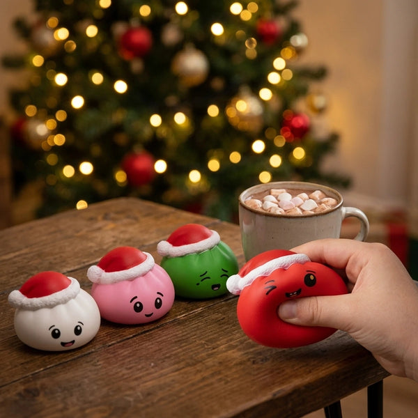 Hand squeezing the red Christmas hat dumpling squishy beside the white, pink and green ones
