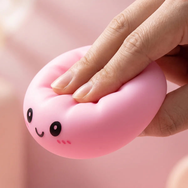 Hands playing with the dumpling squishy mystery box