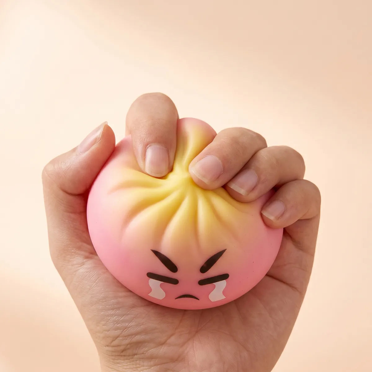 Hands fidgeting with the dumpling squishy mystery bun toy