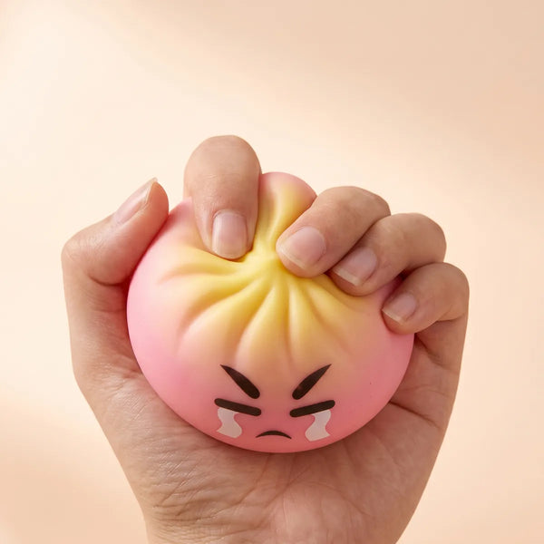 Hands fidgeting with the dumpling squishy mystery bun toy