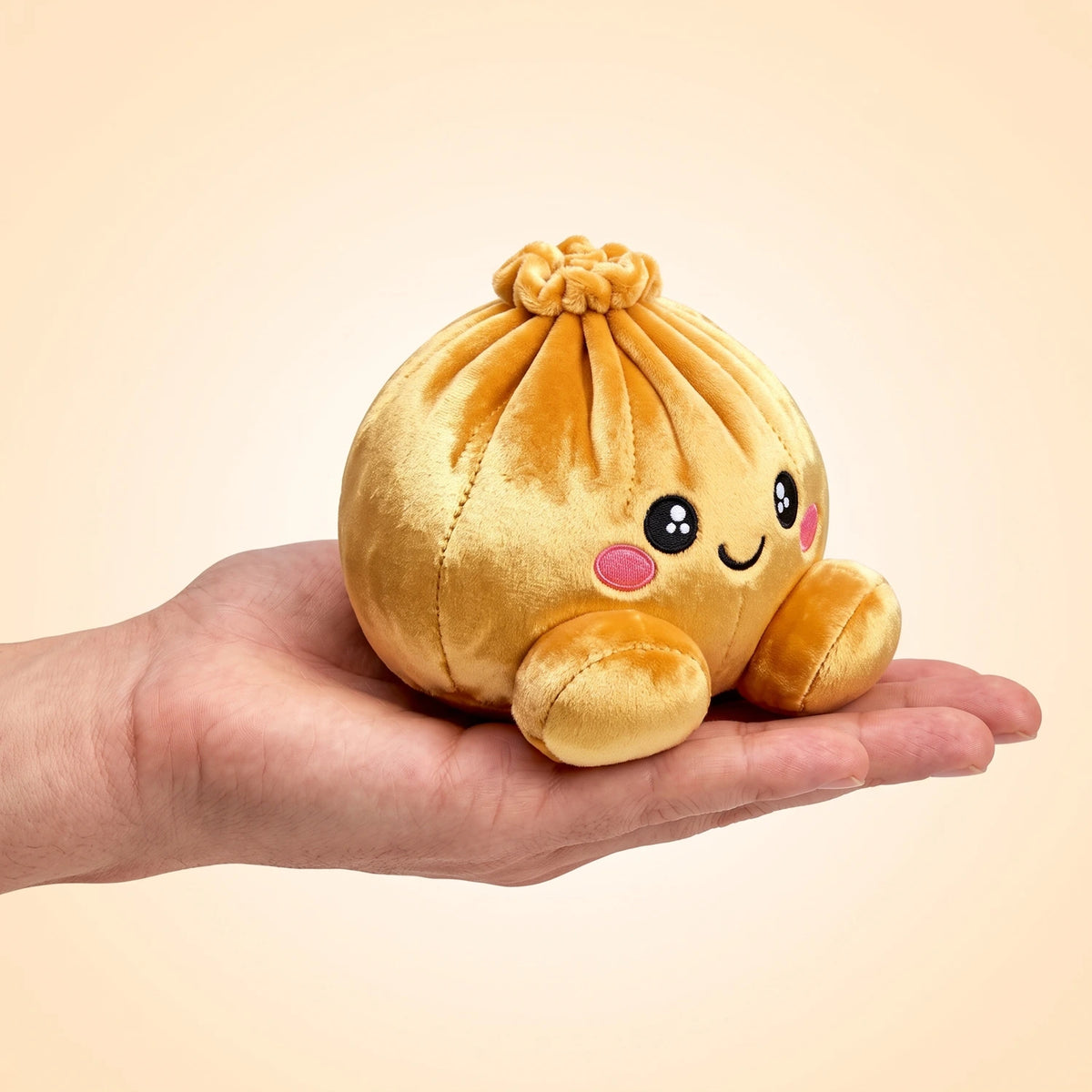 Royal Gold Dumpling Squishy Plush resting on an open palm to show its real size