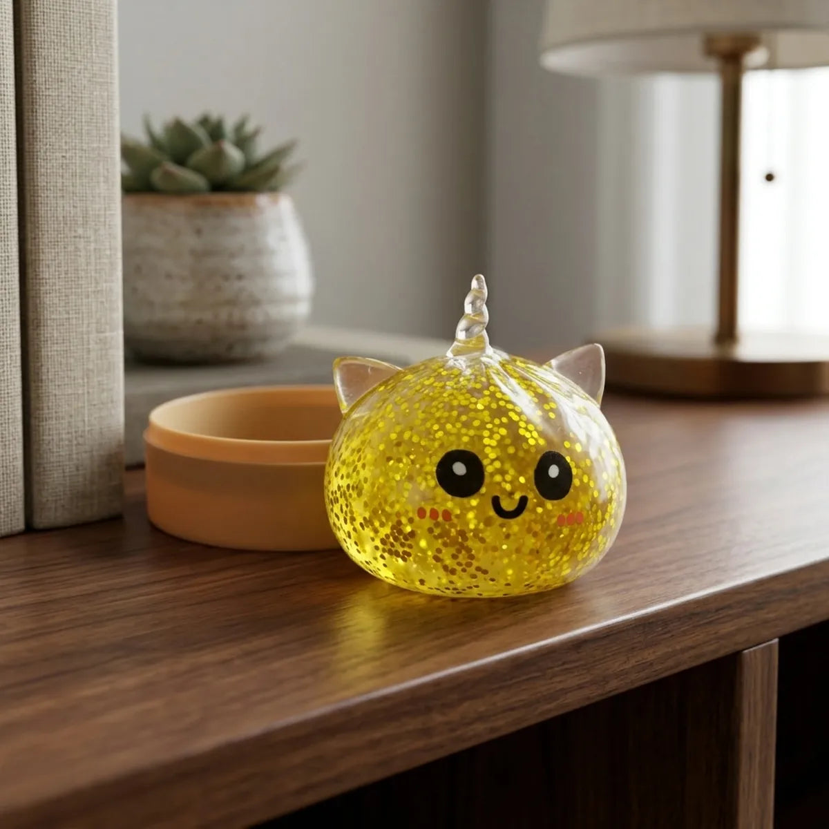 Gold unicorn glitter dumpling squishies displayed on a sparkling gold surface