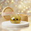 Gold unicorn glitter dumpling squishy with chunky gold glitter and a clear horn on a white podium