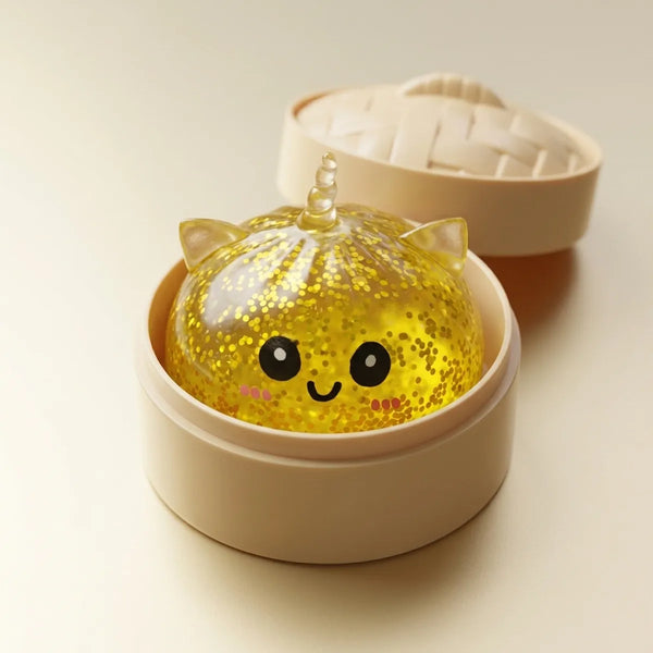 Gold unicorn glitter dumpling squishy resting inside its bamboo steamer box