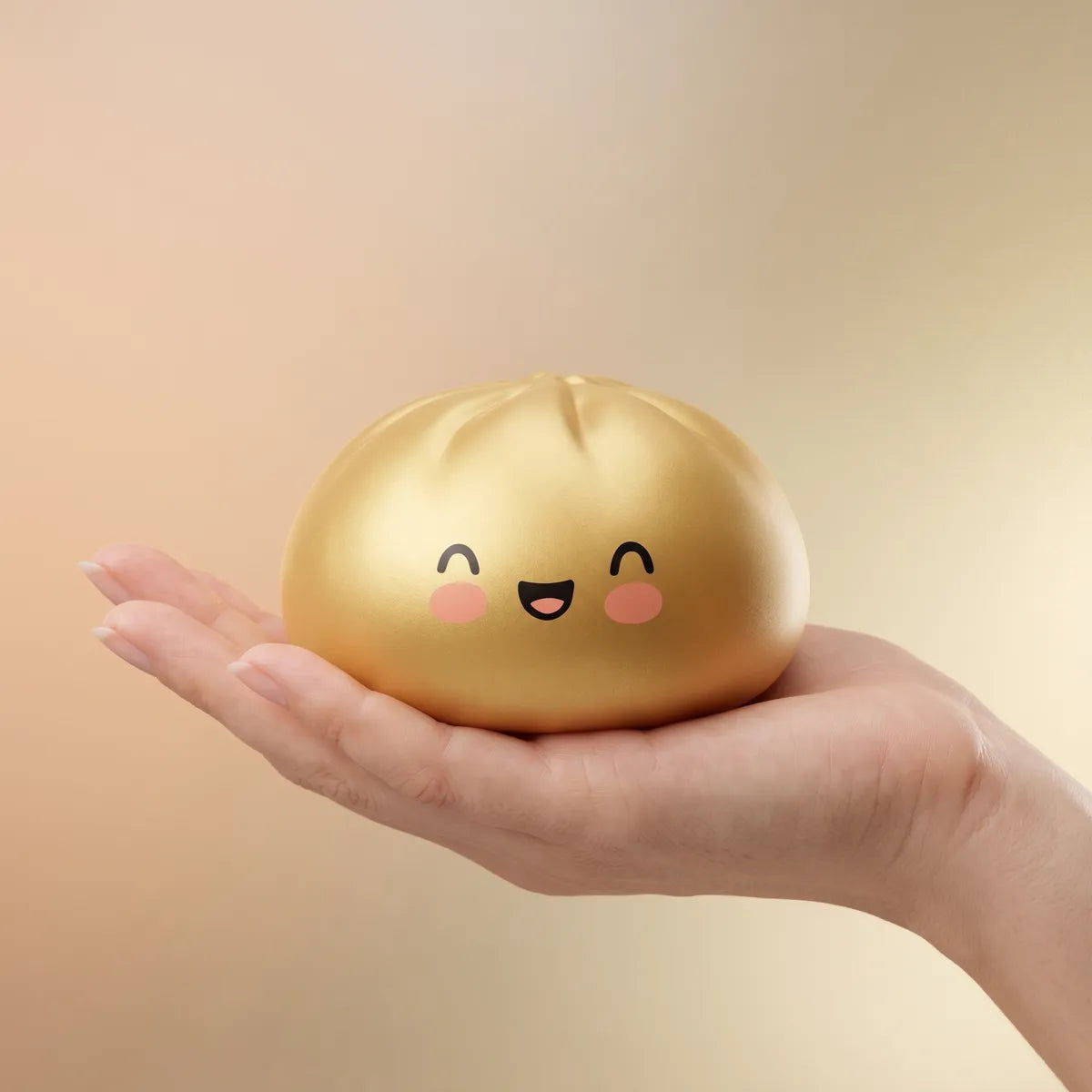 Hand holding a golden dumpling squishy bun
