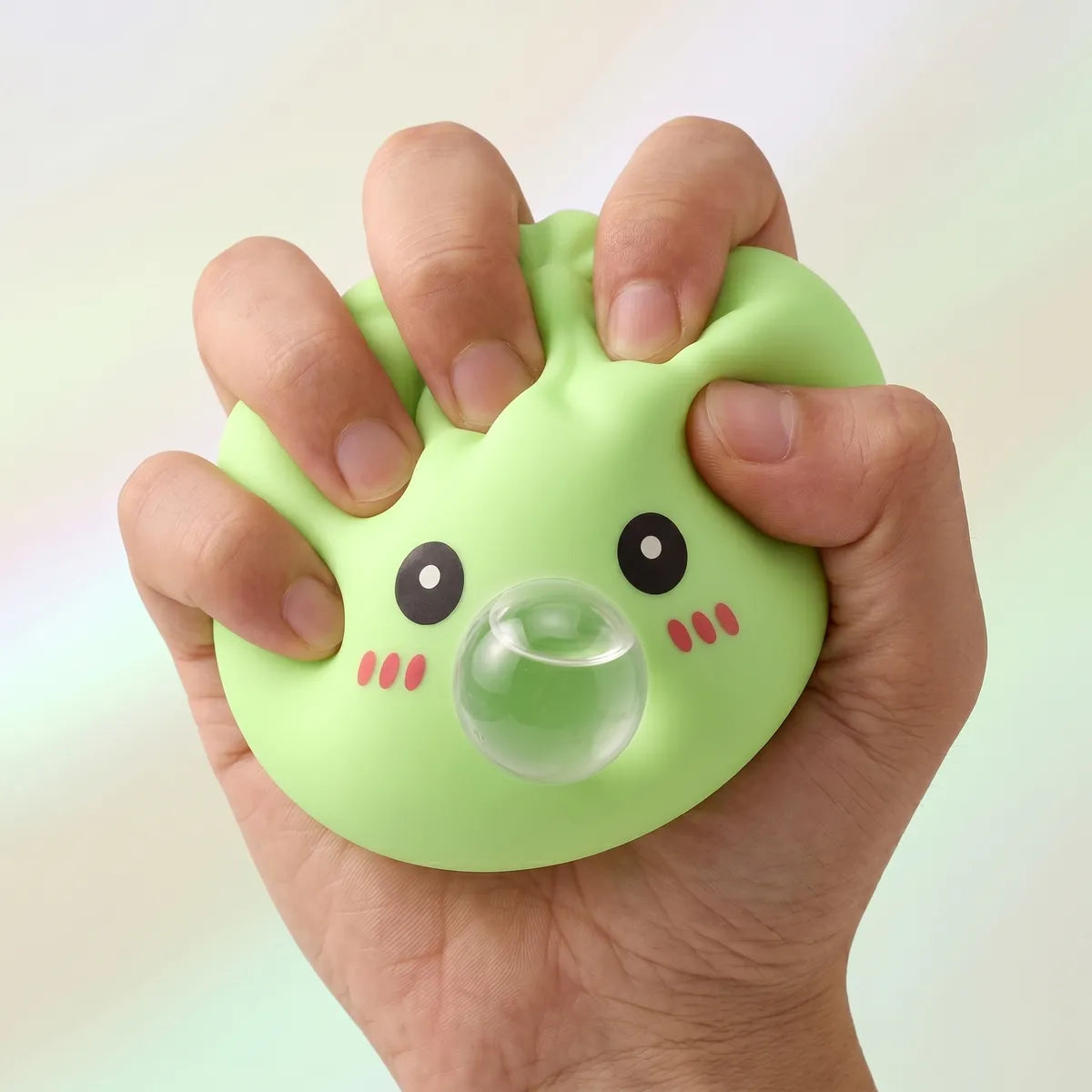Green blow dumpling squishy being squeezed showing slow rising foam