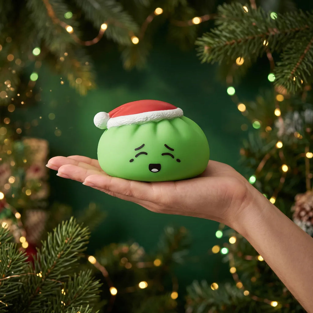 Elf Green Christmas Hat Dumpling Squishy resting on an open palm to show its real size