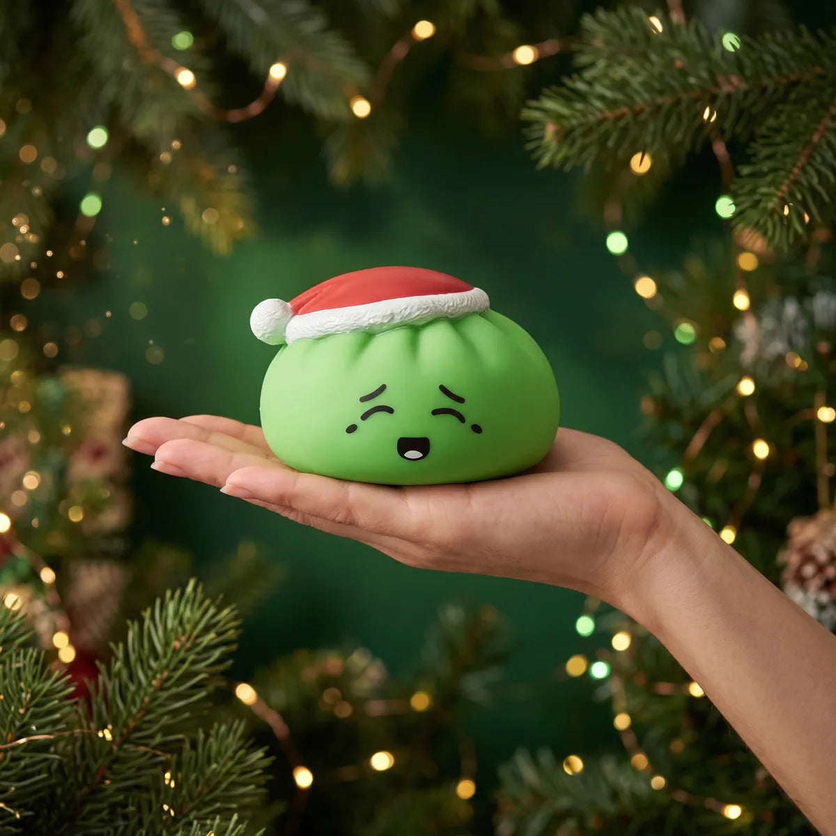 Elf Green Christmas Hat Dumpling Squishy resting on an open palm to show its real size
