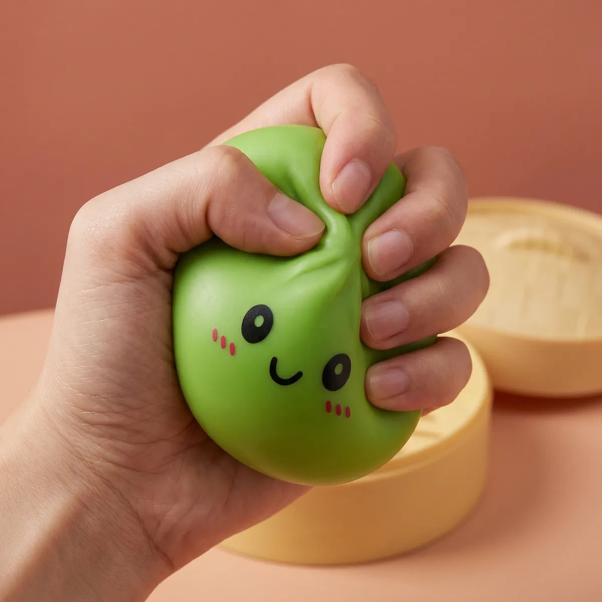 Hands playing with the green dumpling squishy stress toy