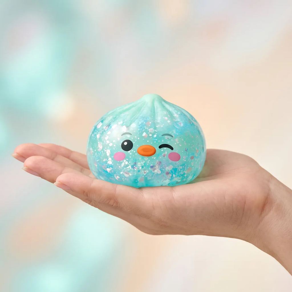 Hand holding the 5.5 cm green penguin dumpling squishy to show its size