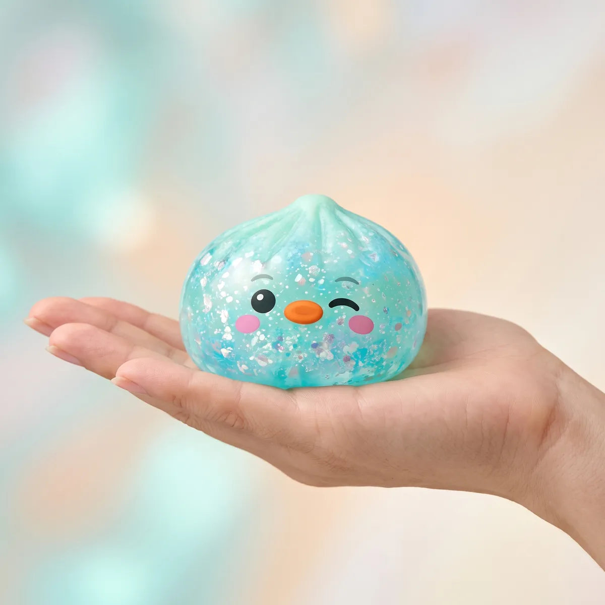 Hand holding the 5.5 cm green penguin dumpling squishy to show its size