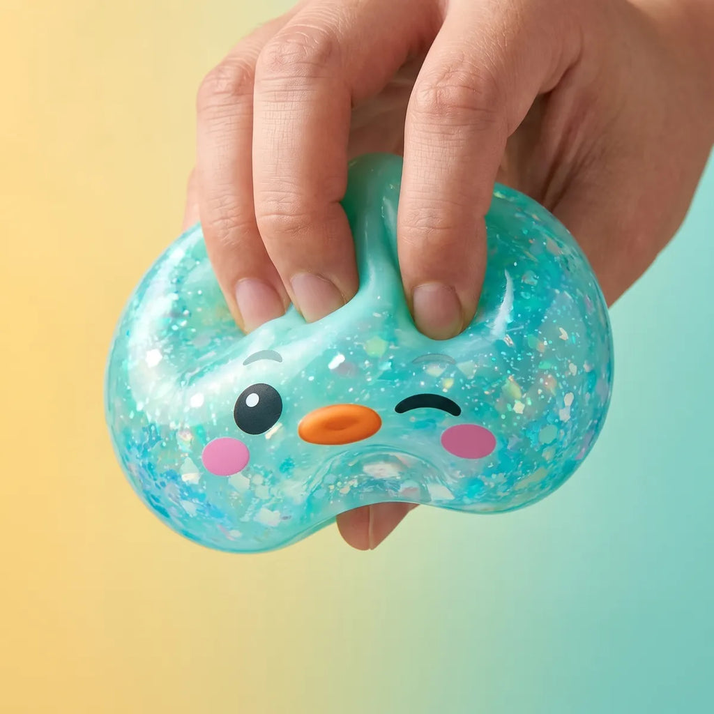 Close up squeeze of the green penguin dumpling squishy showing its iridescent mint flakes