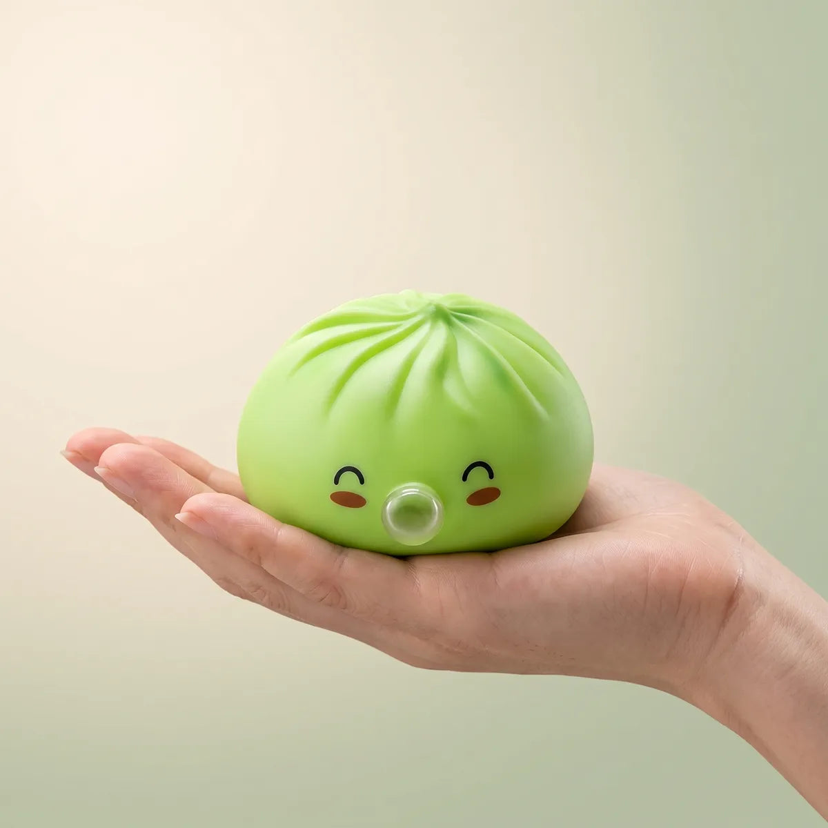 Hand holding a soft green rare blow dumpling squishy