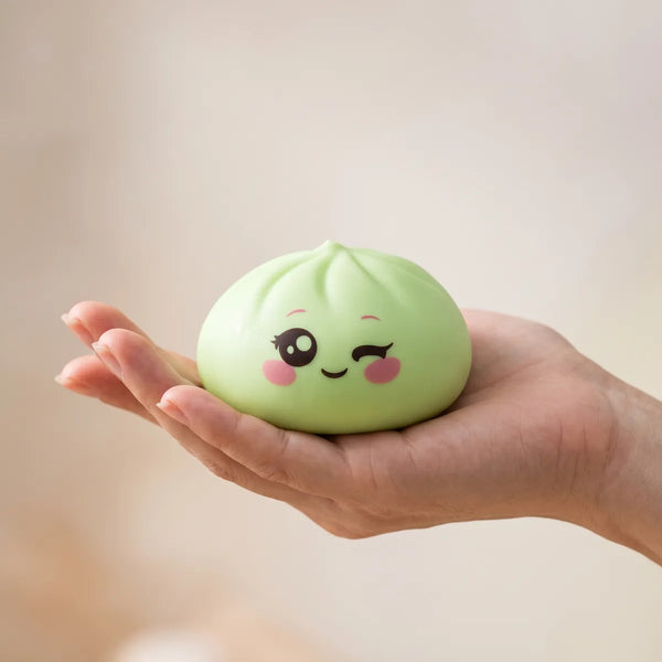 Pistachio Green Wink Dumpling Squishy resting on an open palm to show its real size