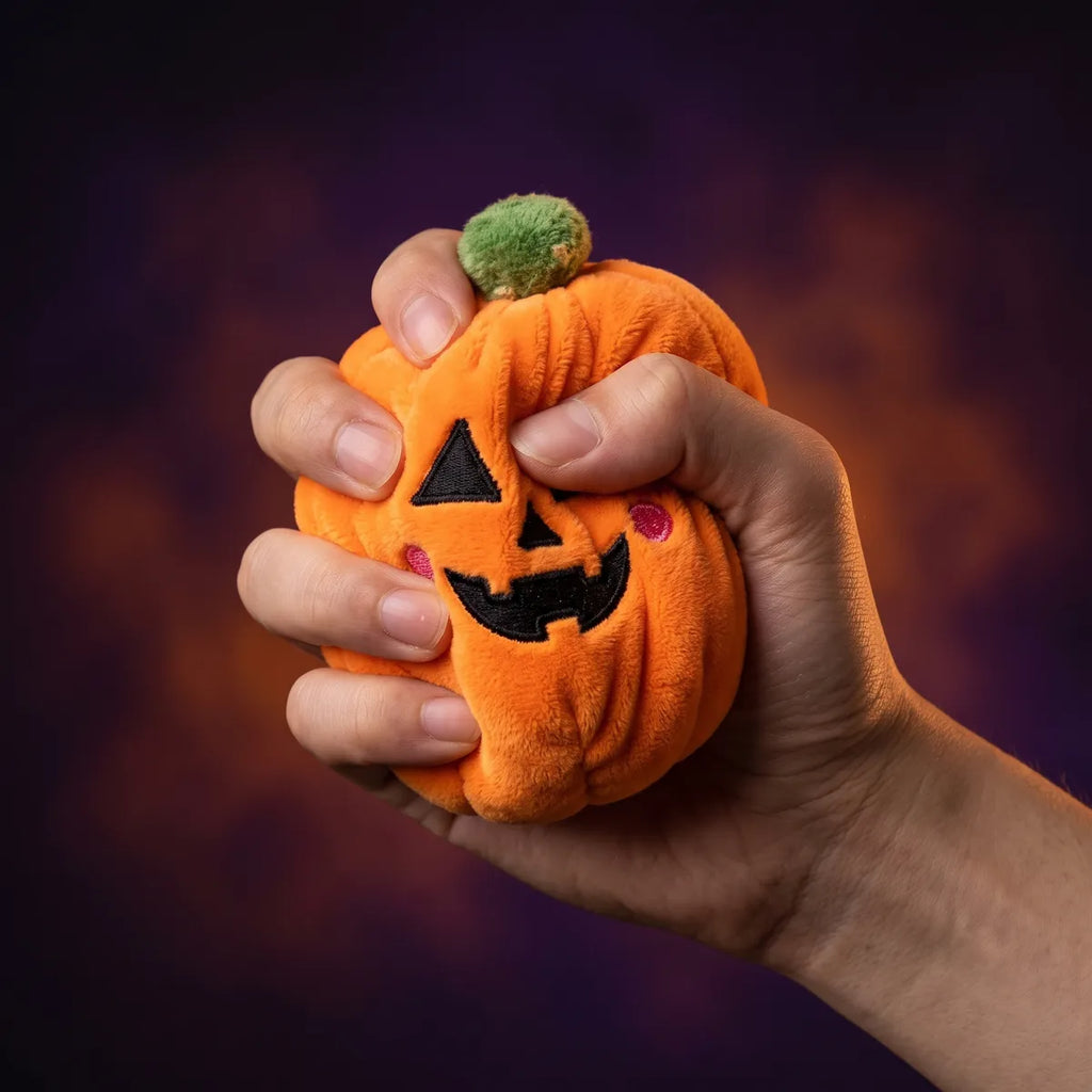 Hand squeezing the pumpkin from the Spooky Halloween Dumpling Squishy Plush 5 Pieces Set