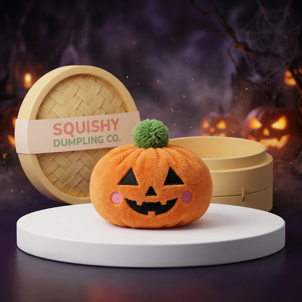 Harvest Halloween Pumpkin Dumpling Squishy Plush on a white studio podium beside a steamer basket