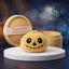 Grinning Halloween Skeleton Dumpling Squishy Plush on a white studio podium beside a steamer basket