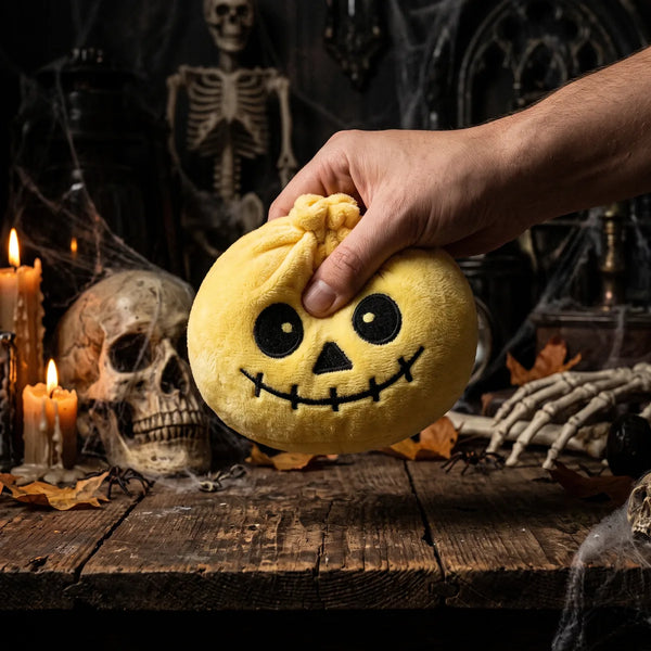 Hand squeezing the Grinning Halloween Skeleton Dumpling Squishy Plush