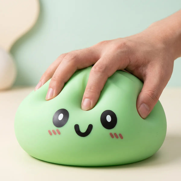 Hand squeezing a large green dumpling squishy