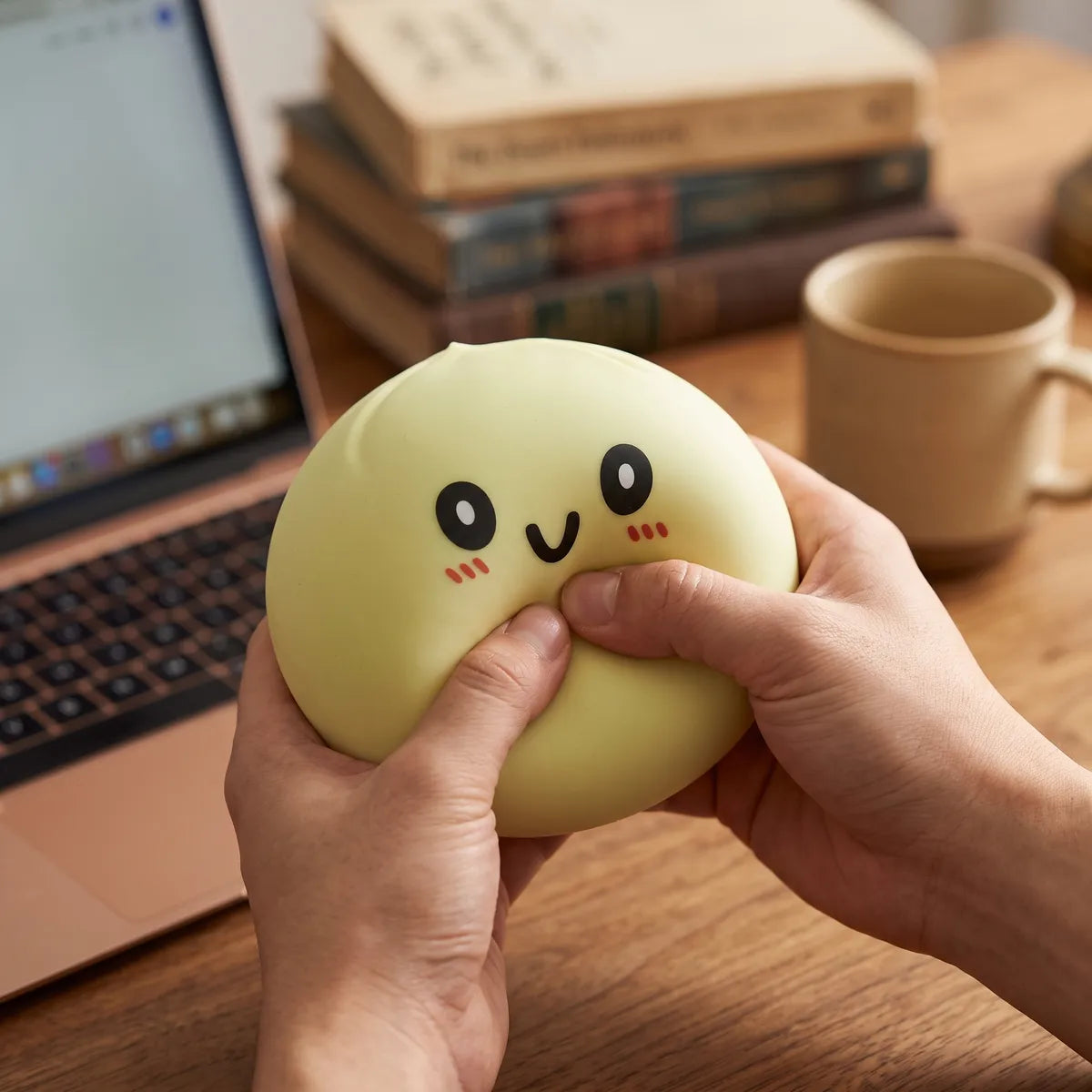 Person using a large yellow dumpling squishy for stress relief