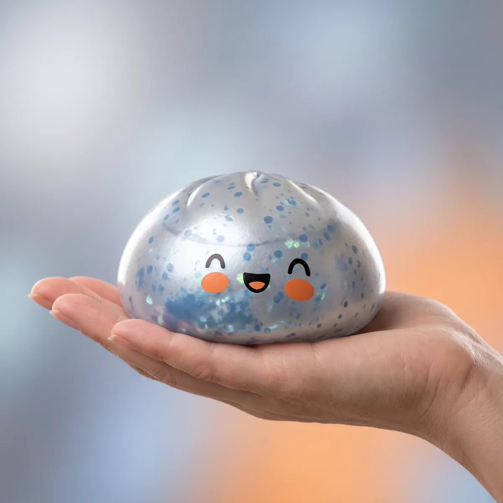 Hand holding a light blue sparkle dumpling squishy