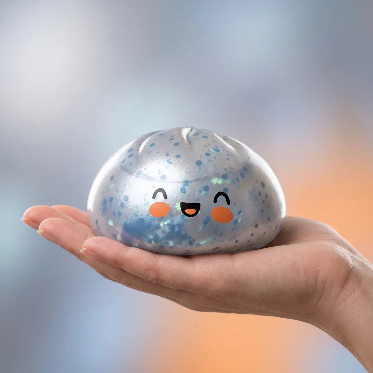 Hand holding a light blue sparkle dumpling squishy