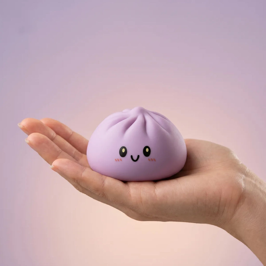 Magenta dumpling squishy held in hand lifestyle shot