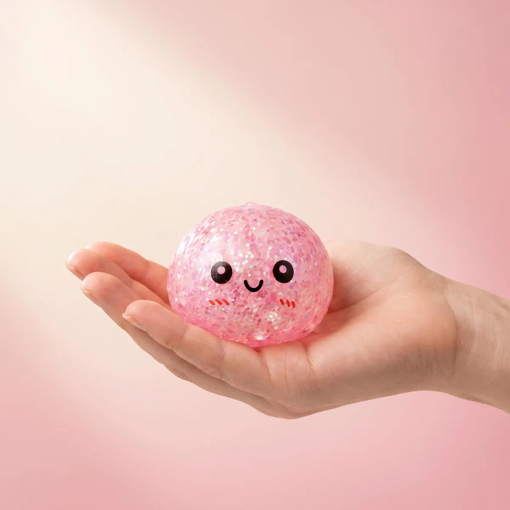 Mini metallic dumpling squishy held in hand to show its size