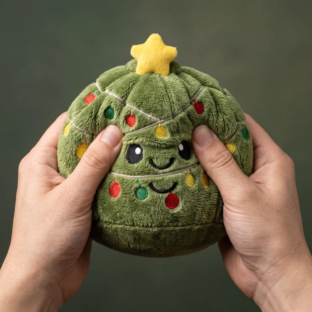 Hand pressing down on the soft Holiday Mystery Christmas Dumpling Squishy Plush