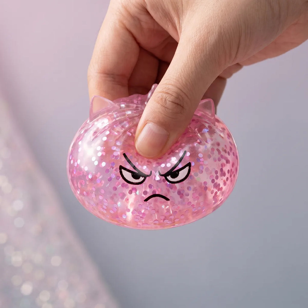 Hands playing with the unicorn glitter mystery dumpling squishy