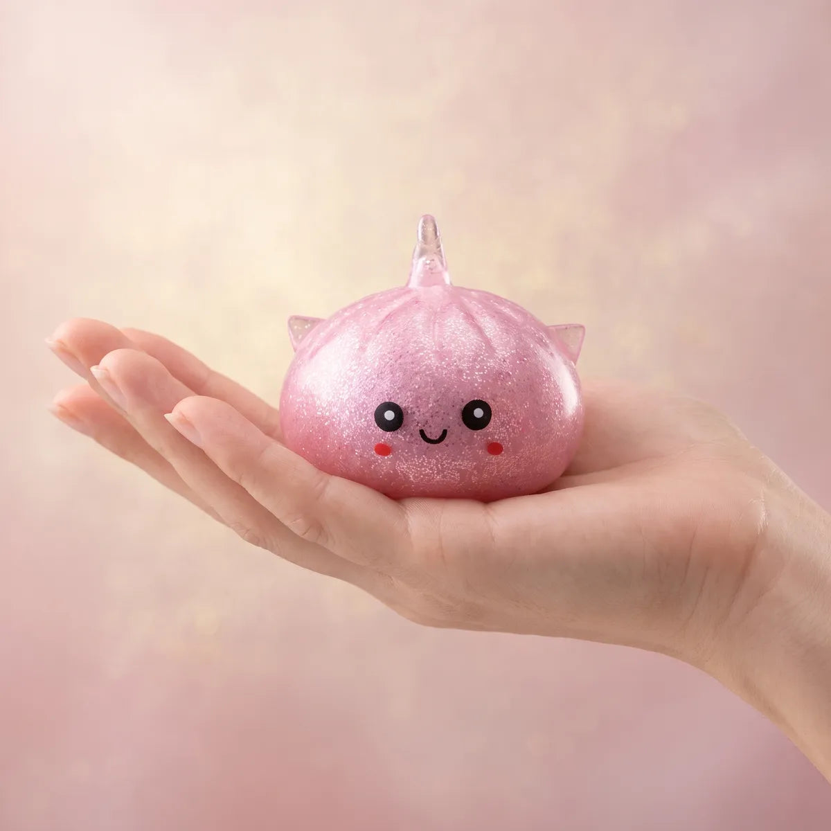 Unicorn glitter mystery dumpling squishy held in hand