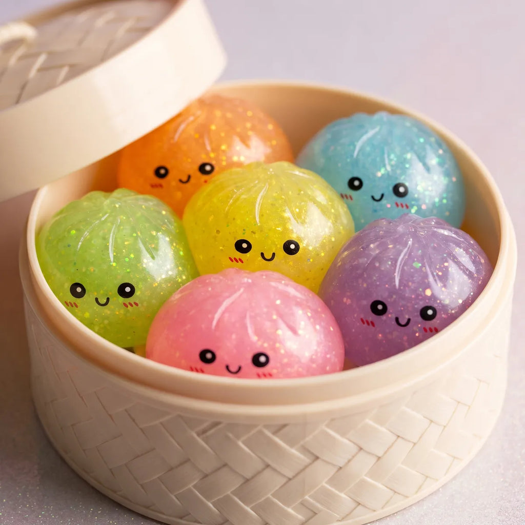 Glow in the dark glitter dumpling squishies inside a bamboo steamer box