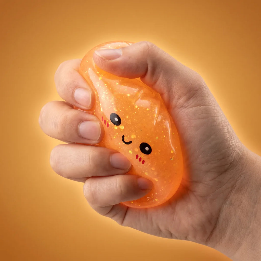 Hand squeezing a glow in the dark glitter dumpling squishy