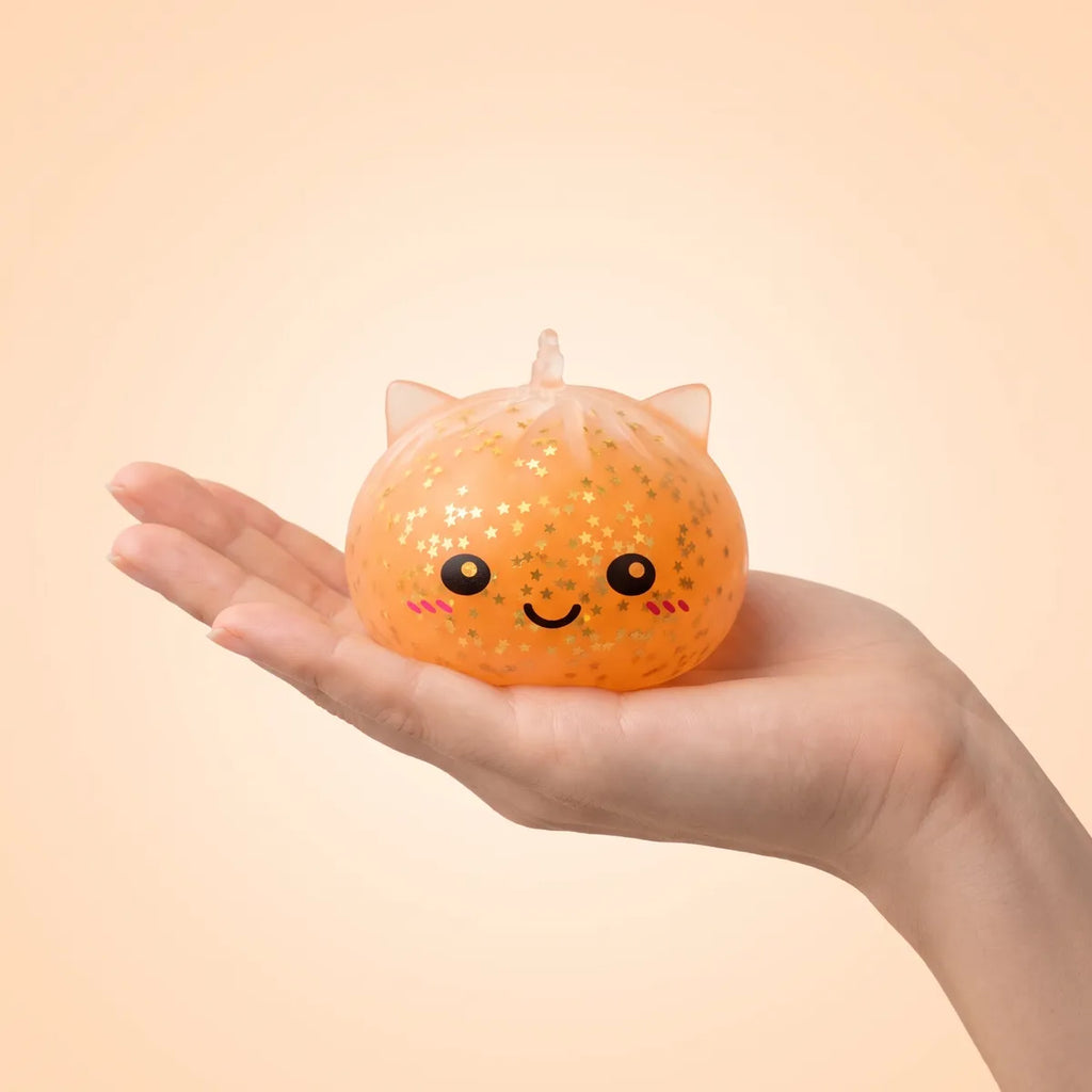 Hand holding the 8 cm sparkle unicorn dumpling squishy to show its real size