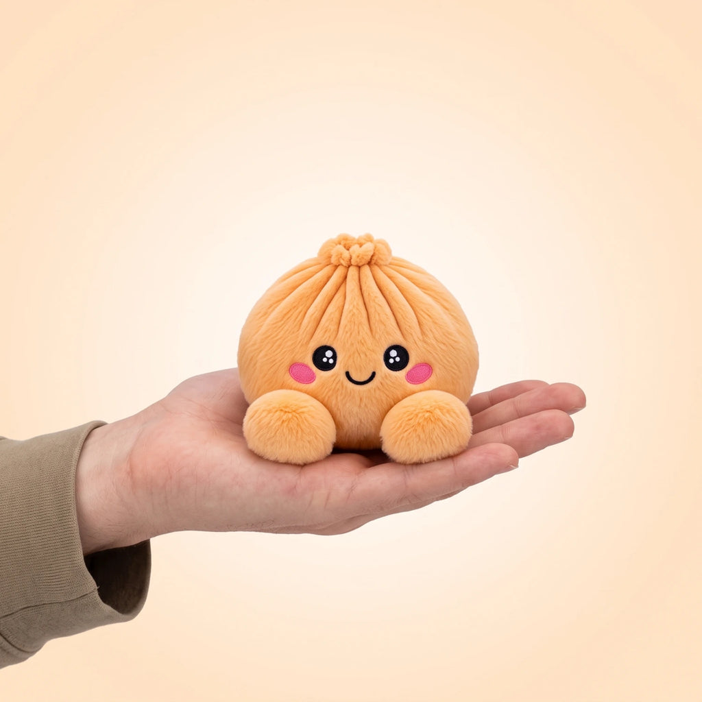 Tangerine Orange Dumpling Squishy Plush resting on an open palm to show its real size