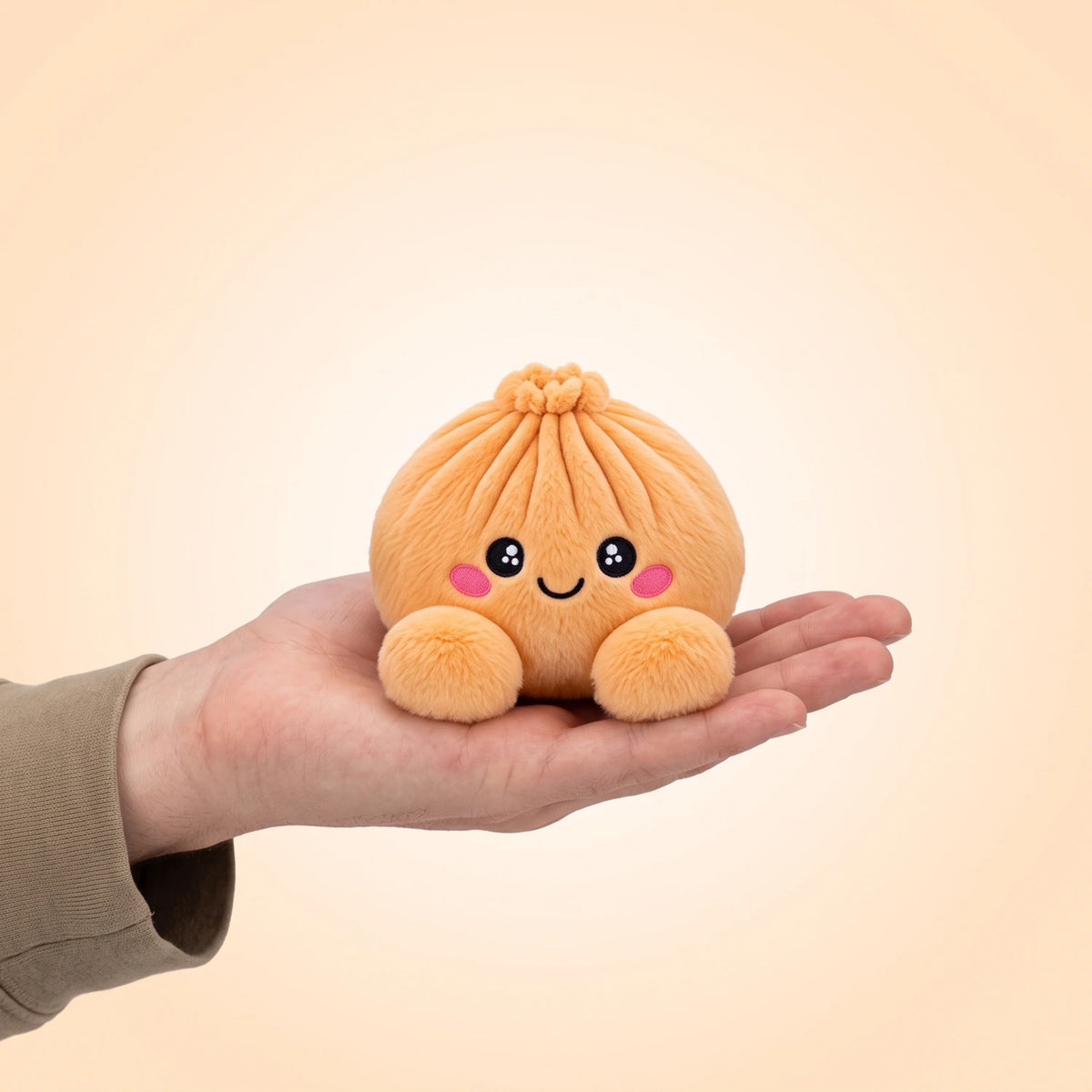 Tangerine Orange Dumpling Squishy Plush resting on an open palm to show its real size