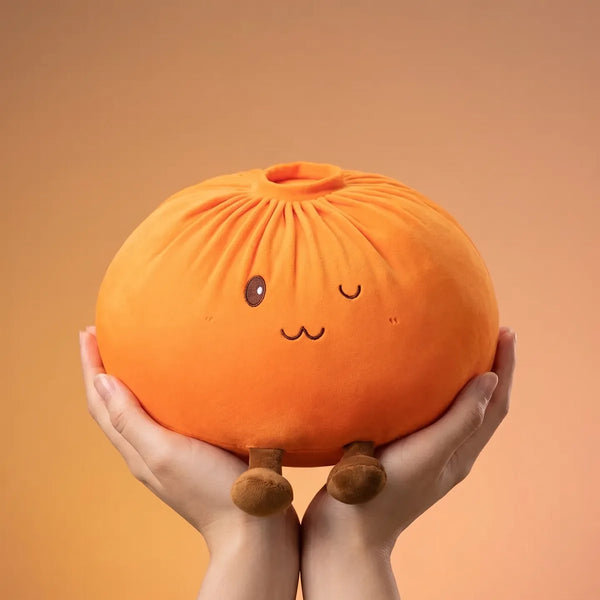 Orange large dumpling squishy plush pillow held to show its size