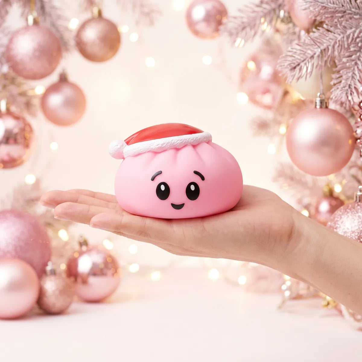 Sugar Pink Christmas Hat Dumpling Squishy resting on an open palm to show its real size