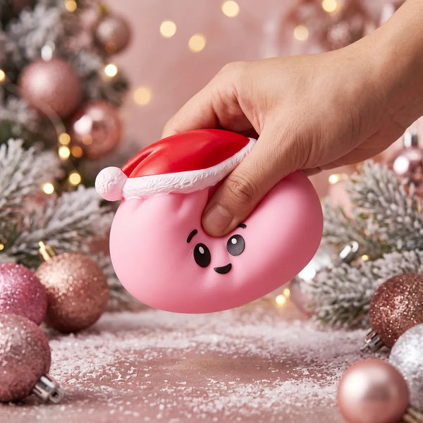 Sugar Pink Christmas Hat Dumpling Squishy pressed flat under a hand before it slowly rises back